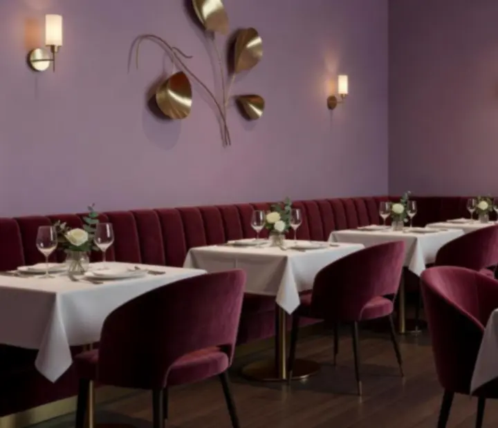 Salle du restaurant Comptoir Lilas avec tables dressées, teintes lilas et détails en bois et bronze